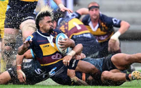 Folau Fakatava slides in the rain in Tonga on Saturday as the Highlanders won the clash against Moana Pasifika.