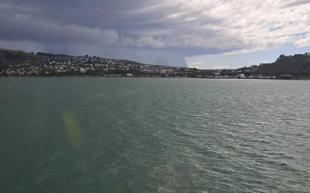 Rain can be seen from a train in Wellington looking across toward and beyond Titahi Bay as a severe thunderstorm warning is put in place.
