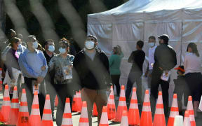 People wait in long lines for covid tests at a walk-up Covid-19 testing site in San Fernando, California.