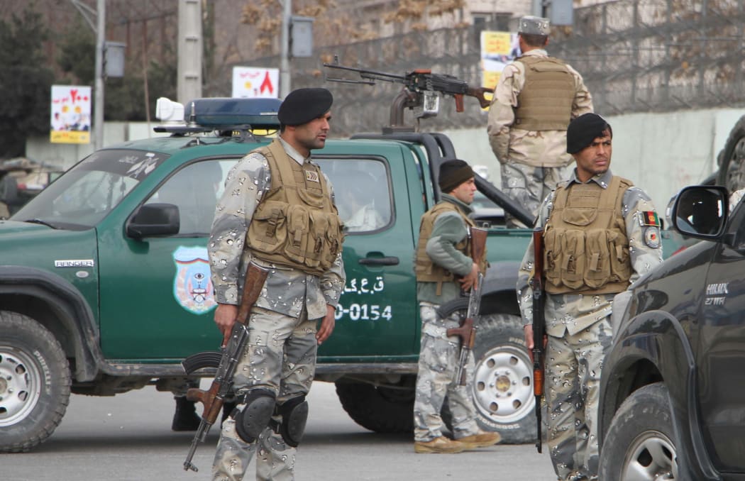 Afghan security forces block the roads after gunmen dressed as doctors attacked a Kabul hospital, killing 30 people.