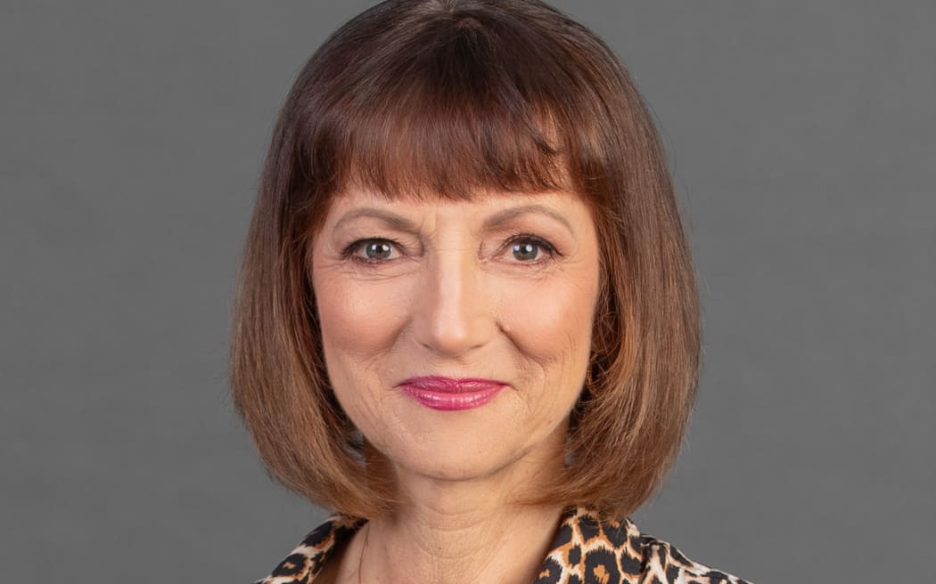 Smiling Louise Pagonis with a grey background