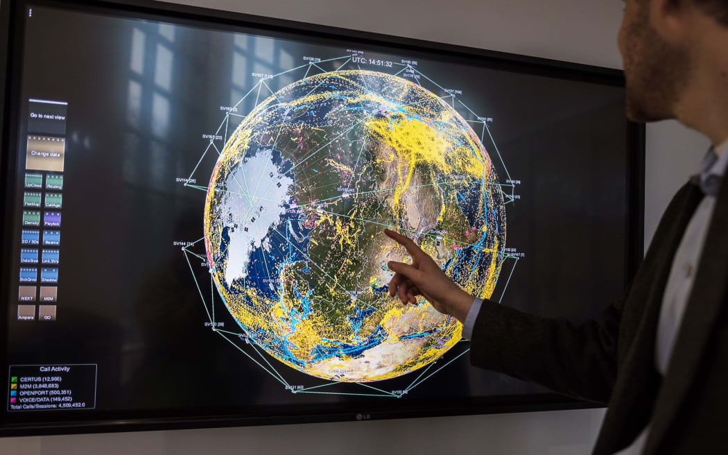 A worker points to a monitor displaying current satellites in orbit and real-time communications across the globe at the Iridium Communications Inc. Satellite Network Operations Center in Leesburg, Virginia.