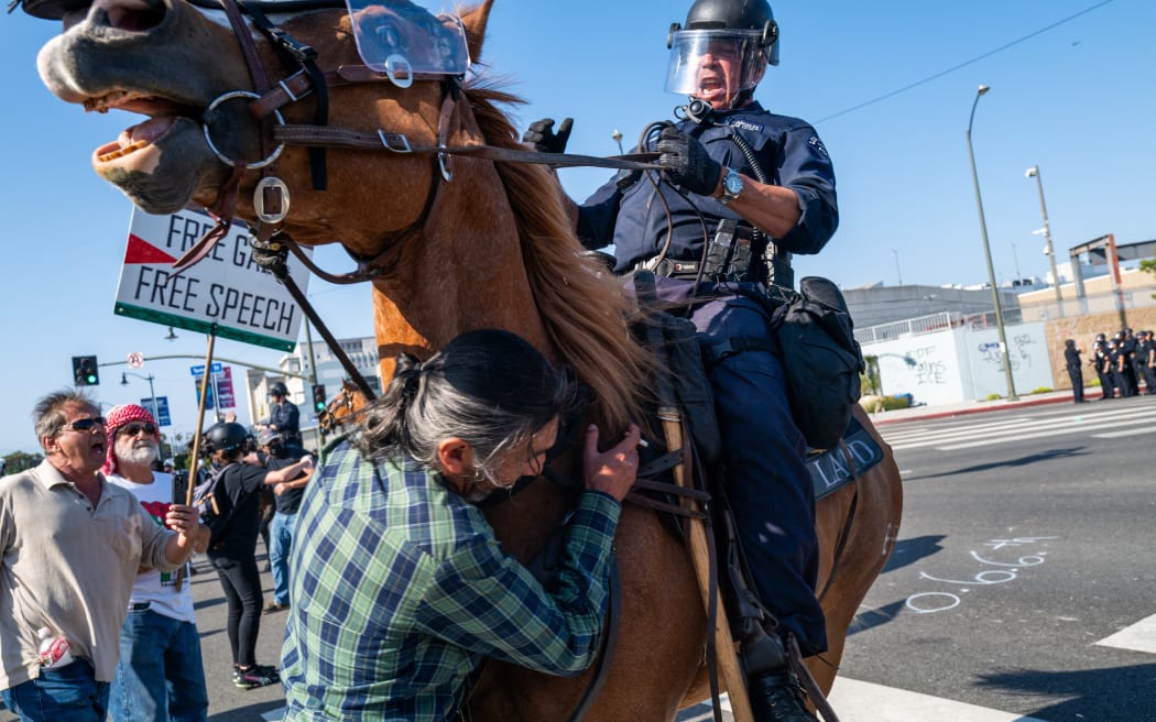 LAPD officers on horseback clash with protesters during protests after a series of immigration raids in Los Angeles.