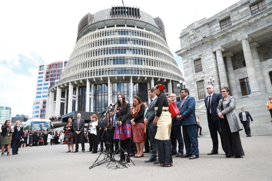New PM Jacinda Ardern, flanked by her government, speaks to the public at Parliament.