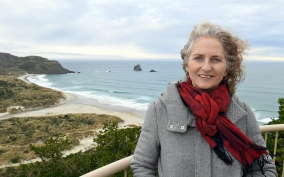 For the penguins sake . . .  Reasearchers have suggested closing off beaches to allow penguins to breed in peace. Yolanda van Heezik with Sandfly bay in behind.