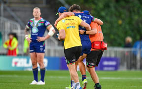 Luke Metcalf of the Warriors is helped off the field.