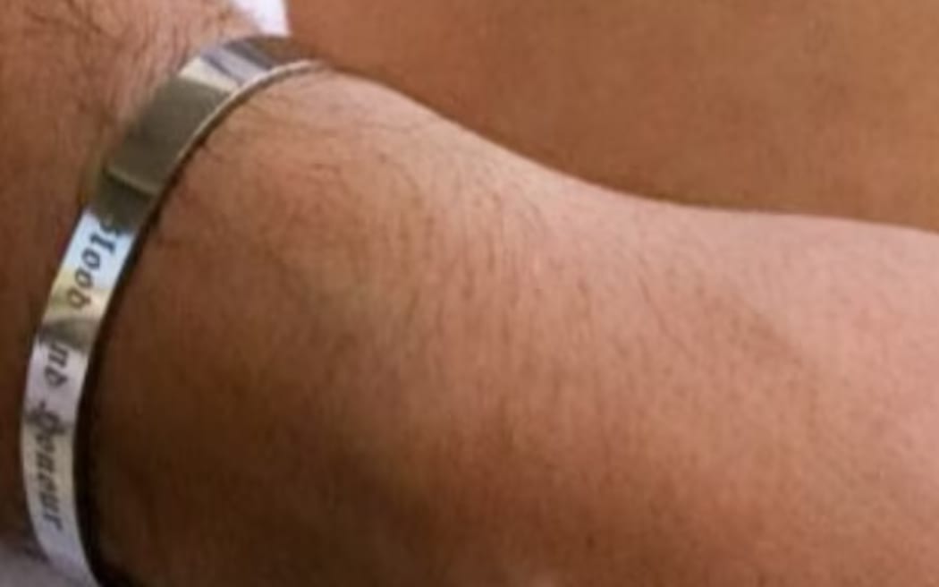 A picture of a bracelet taken from the social media of the wife of Matthew Gruter. The phrase "blood and honour" is linked to Nazis.
