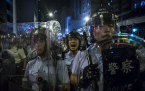A police officer yells instructions during a protest against an expected interpretation of the city's constitution, the Basic Law, by China's NPCSC.
