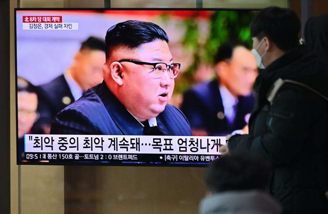 People watch a television screen showing news footage of North Korean leader Kim Jong Un attending the 8th congress of the ruling Workers' Party held in Pyongyang, at a railway station in Seoul on January 6, 2021.