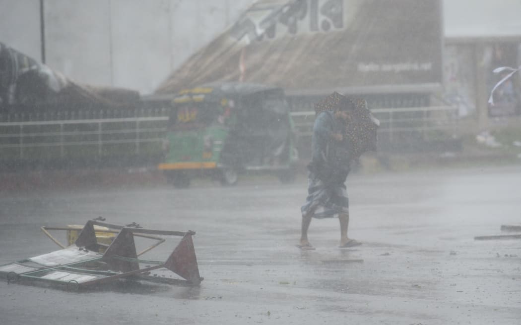 A pedestrian makes his way under heavy rain as cyclone Bulbul approaches the area in Khulna on November 10, 2019.