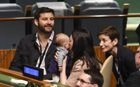 Jacinda Ardern kisses daughter Neve ans as her husband Clarke Gayford  looks on during the Nelson Mandela Peace Summit at the UN in New York.