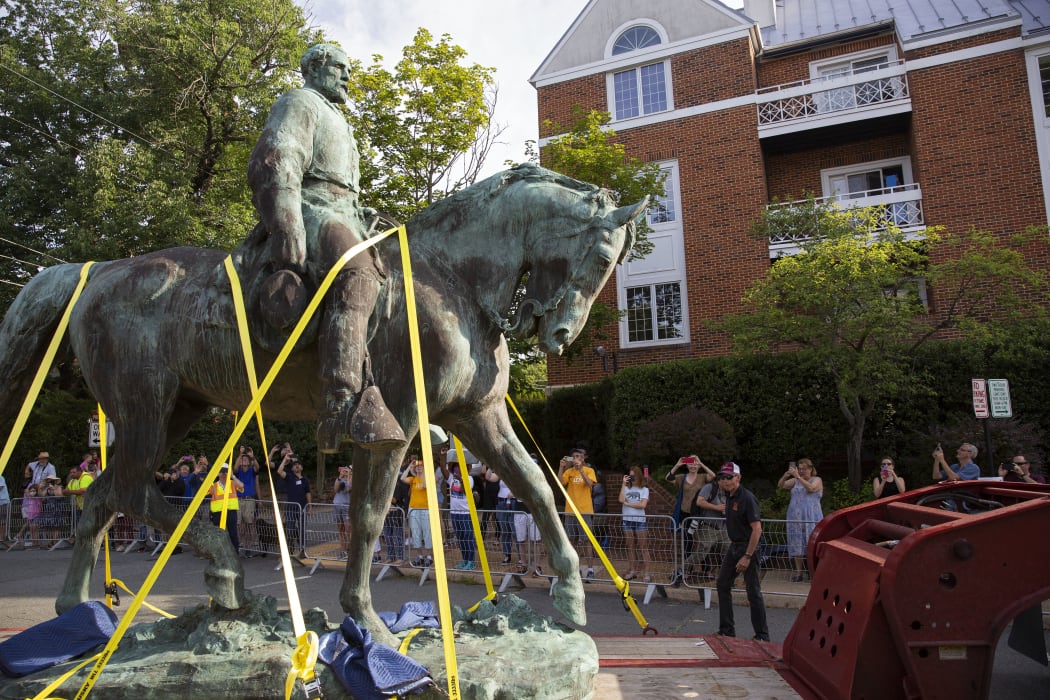 People watch as the statue of Confederate General Robert E. Lee is removed from a park in Charlottesville, Virginia.