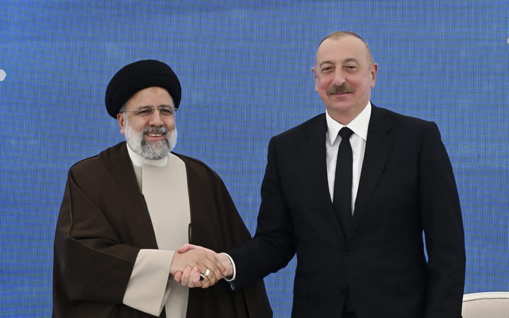 En esta fotografía proporcionada por la Oficina de Prensa Presidencial de Azerbaiyán, el presidente iraní, Ibrahim Raisi, a la izquierda, le da la mano a su presidente azerí, Ilham Aliyev, durante su reunión en la inauguración de la presa de Kis Qalasi, o Castillo de la Doncella, en la frontera.  Irán y Azerbaiyán, domingo 19 de mayo de 2024. Se estrelló el helicóptero en el que viajaba el presidente iraní, Ibrahim Raisi. "Aterrizaje forzoso" El domingo, los medios estatales iraníes publicaron la noticia sin dar más detalles de inmediato.