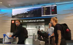 Travellers with face masks at Auckland Airport international arrivals during the Covid-19 coronavirus outbreak on 20/3/2020.