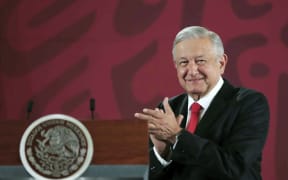 Handout picture released by the Mexican Presidency showing Mexican President Andres Manuel Lopez Obrador applauding during a press conference at the National Palace in Mexico City on December 27, 2019.