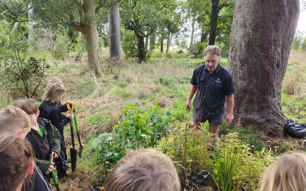 Trevor Thompson of the QEII Trust starts off the planting morning naming the plants to go in