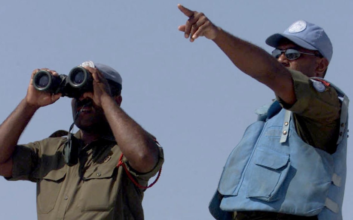 A Fijian UN peacekeeper looks through binoculars at an Israeli post from the Al-Labbouneh hill near Naqoura on the Mediterranean coast 30 July 2000 where fifty Fijian troops took up position.