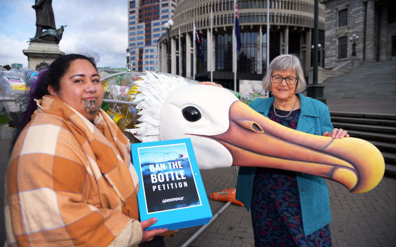 Juressa Less presents the 'ban the bottle' petition to MP Eugenie Sage, with 'Birdy' the Toroa sculpture, made of single-use plastic bottles.