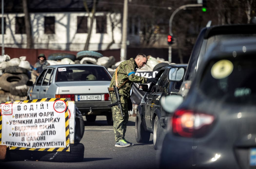 A member of the Ukrainian Territorial Defence Forces checks cars at a checkpoint in Kyiv, on March 20, 2022.