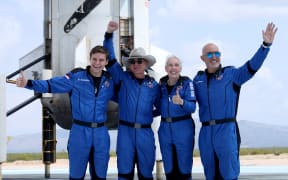 Blue Origin's New Shepard crew (L-R) Oliver Daemen, Jeff Bezos, Wally Funk, and Mark Bezos pose for a picture near the booster after flying into space in the Blue Origin New Shepard rocket on 20 July 20, 2021 in Van Horn, Texas.