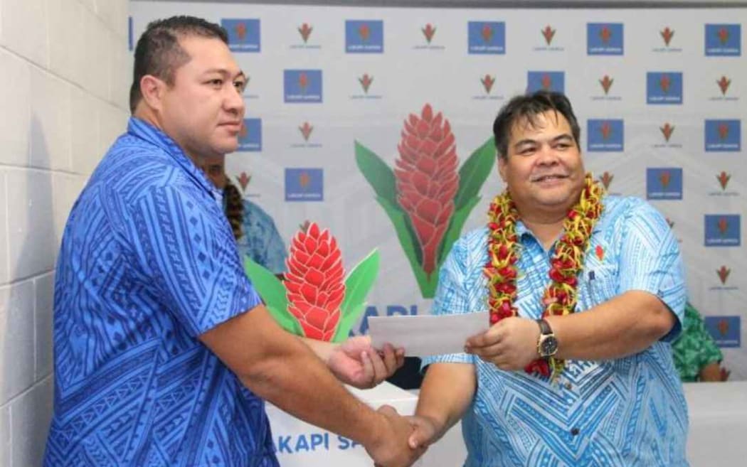 Logo designer Irwin Kennar (L) is presented with a $1000 cheque by Lakapi Samoa Chief Executive Faleomavaega Vincent Fepuleai.