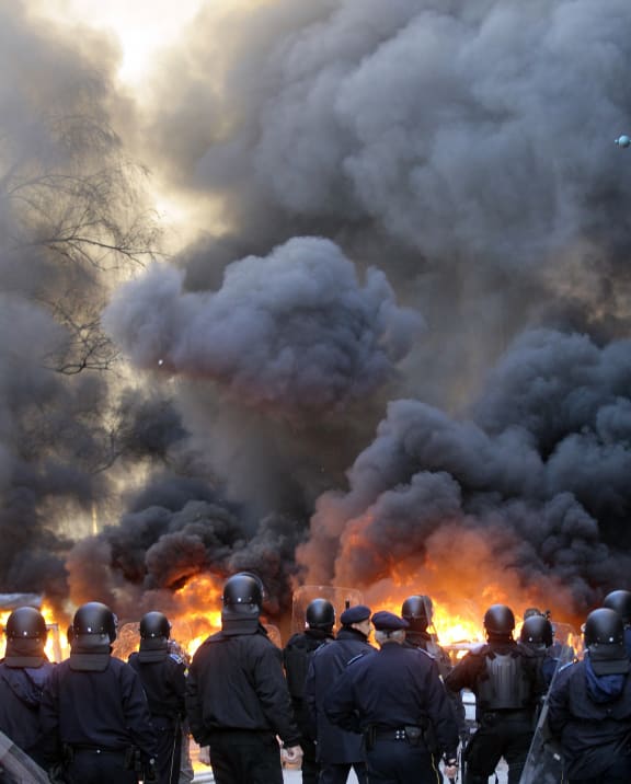 Police try to hold off protesters as fire rages in Sarajevo.