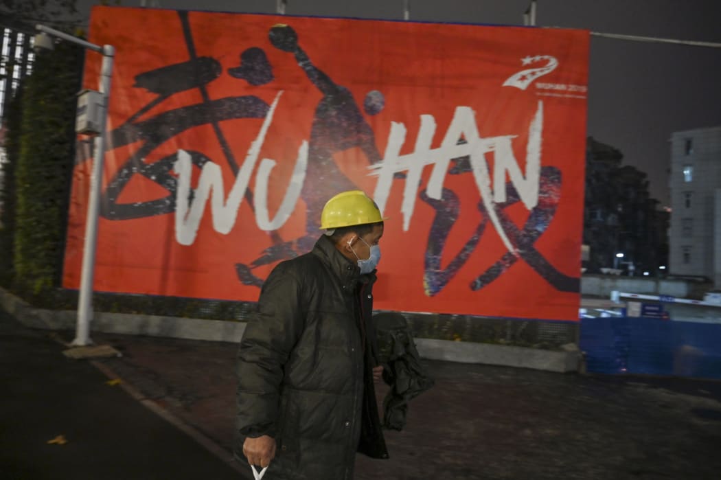 A man wearing a protective facemask walks along a street in Wuhan on 26 Januar, a city at the epicentre of a novel coronavirus outbreak.