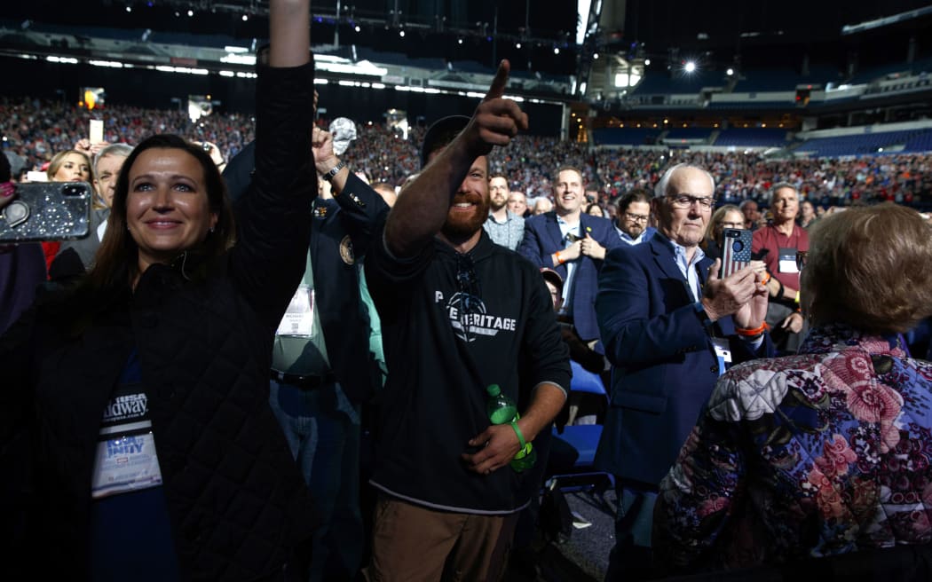 A man points at President Donald Trump after he tossed his cellphone toward the stage as Trump arrived to speak to the annual meeting of the National Rifle Association, Friday, April 26, 2019, in Indianapolis.
