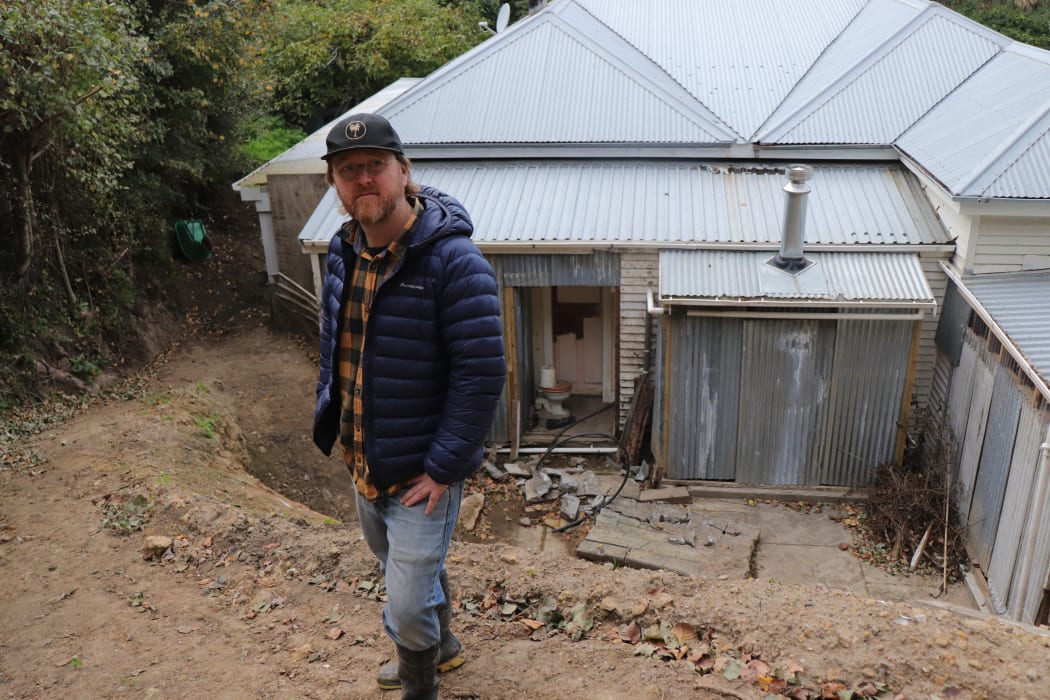 Six months ago, this was a slip but now Freeman White stands at the cleared area of his home.