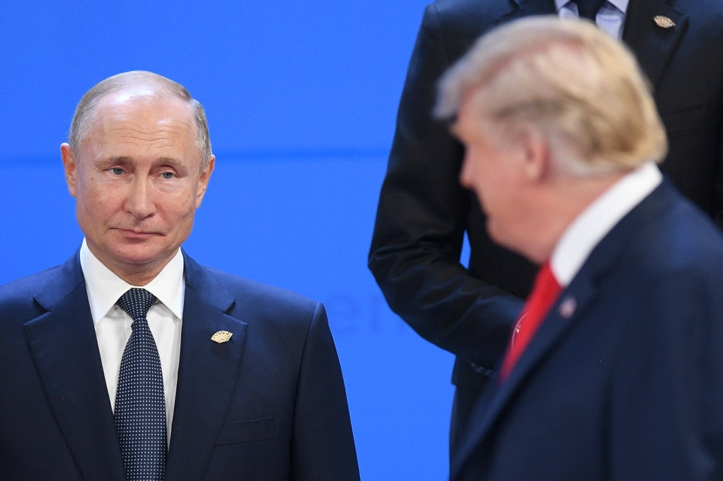 Russian President Vladimir Putin, left, looks at US President Donald Trump before posing for a family photo before the G20 summit in Argentina, 30 November, 2018.