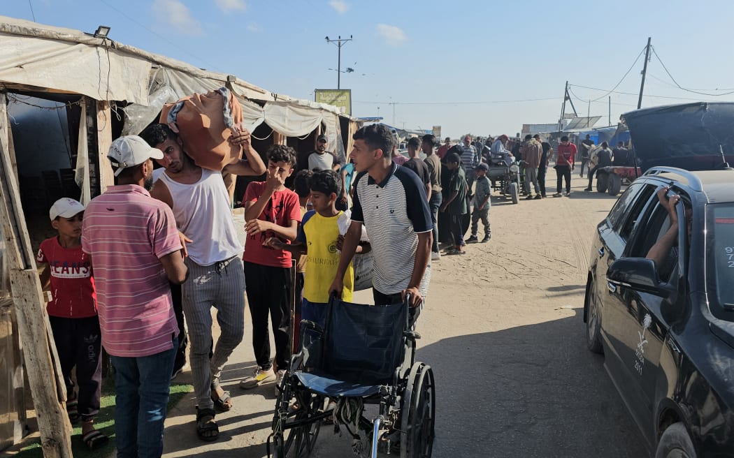 Displaced Palestinians receive food packages from a US-backed foundation pledging to distribute humanitarian aid in western Rafah in the southern Gaza Strip.