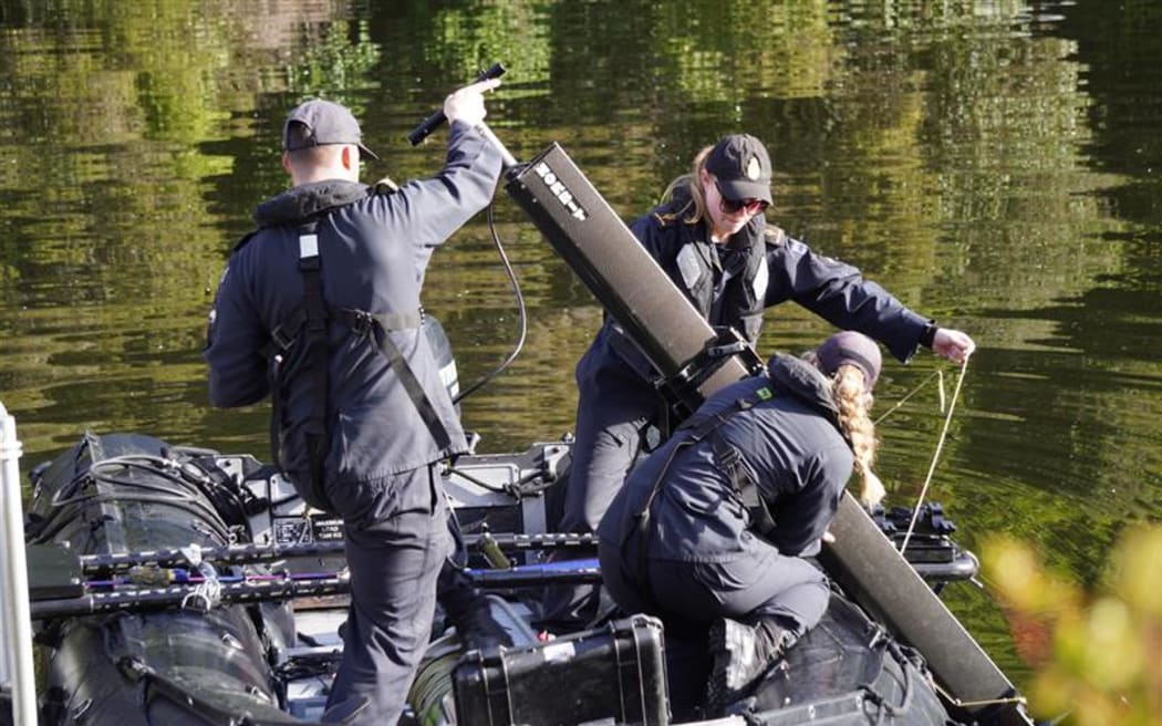 The Navy crew sets up their surveying equipment aboard the Zodiac on Wednesday morning.