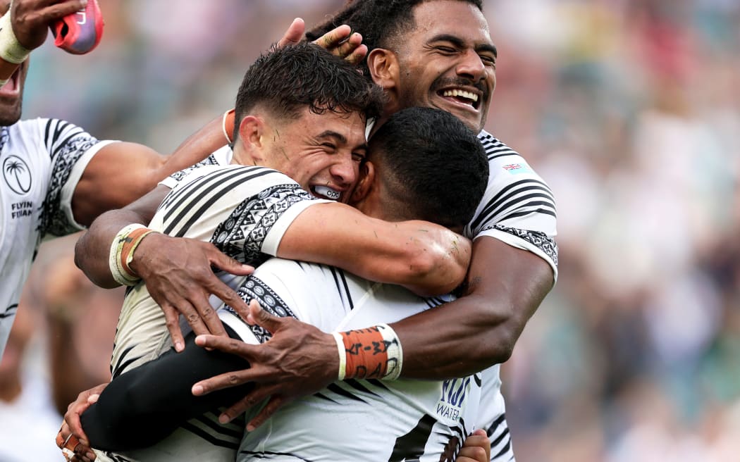 Fiji's Caleb Muntz celebrates after the game with Selestino Ravutaumada and Zuriel Togiatama after beating England at Twickenham, 2023.