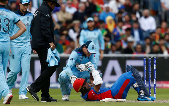Hashmatullah Shahidi of Afghanistan  receives attention after being hit on the helmet England bowler by Mark Wood during a World Cup match in Manchester.