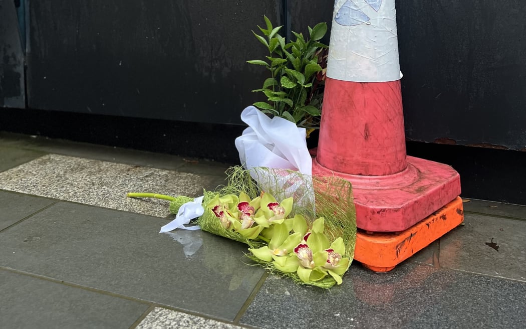 Flowers laid outside the barriers of the construction site, on 21 July 2023, the day after the shootings.