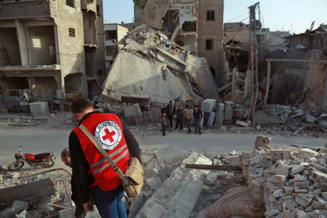 A International Red Cross volunteer stands above the rubble of a destroyed building in Douma, Eastern Ghouta, Syria on March 5, 2018.
