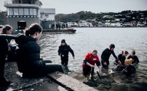 Rescuers and volunteers keep watch over a stranded baby orca at Plimmerton, Wellington.