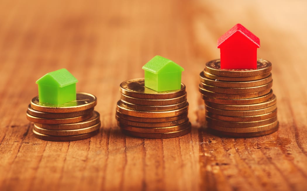 House price rises, as illustrated by houses stacked on top of coins.