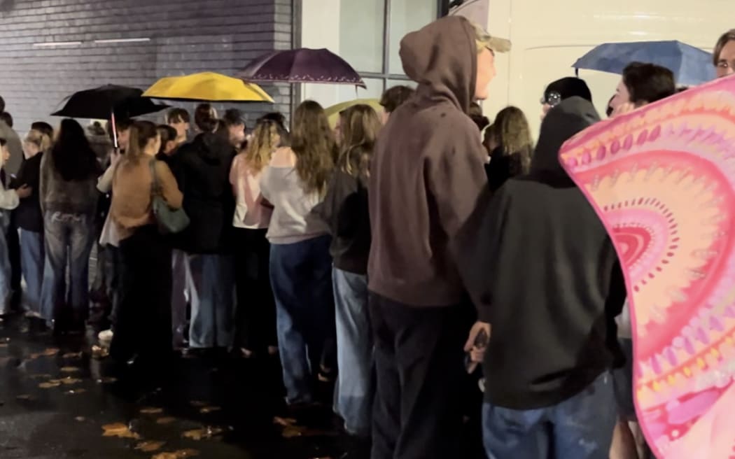 People queueing in the rain.