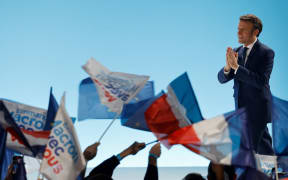 French President and La Republique en Marche (LREM) party candidate for re-election Emmanuel Macron gestures prior to addressing sympathizers after the first results of the first round of France's presidential election at the Paris Expo Porte de Versailles Hall 6 in Paris, on April 10, 2022.