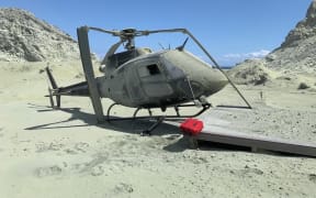 A damaged helicopter is seen on White Island after the eruption.