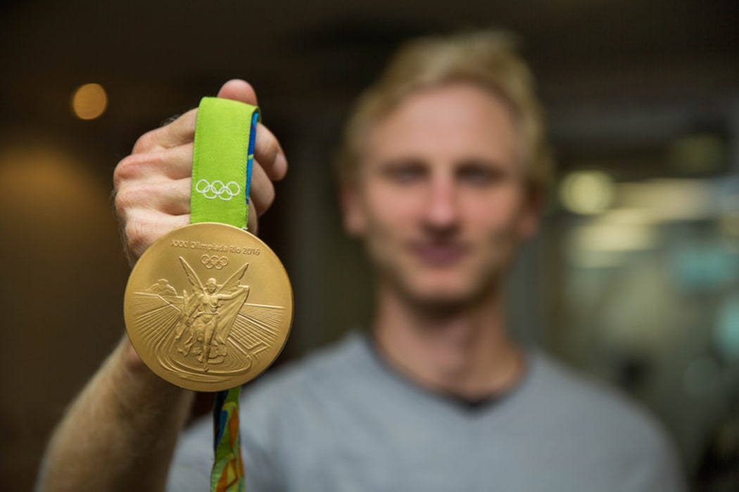 Hamish Bond holding his Olympic gold medal from the Rio 2016 Olympics