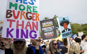 People participate in a "No Kings" national day of protest in Washington, DC, on October 18, 2025. From New York to San Francisco, millions of Americans are expected to hit the streets to voice their anger over President Donald Trump's policies at nationwide "No Kings" protests. (Photo by Amid FARAHI / AFP)