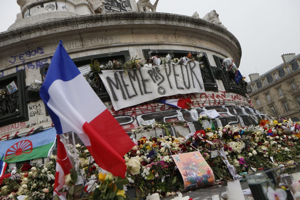 A picture taken on November 27, 2015, shows French national flags, candles and flowers at a makeshift memorial in Place de la Republique square in Paris.