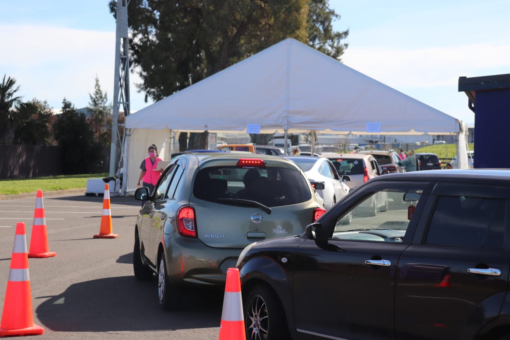 Cars line up as people wait to get vaccinated.