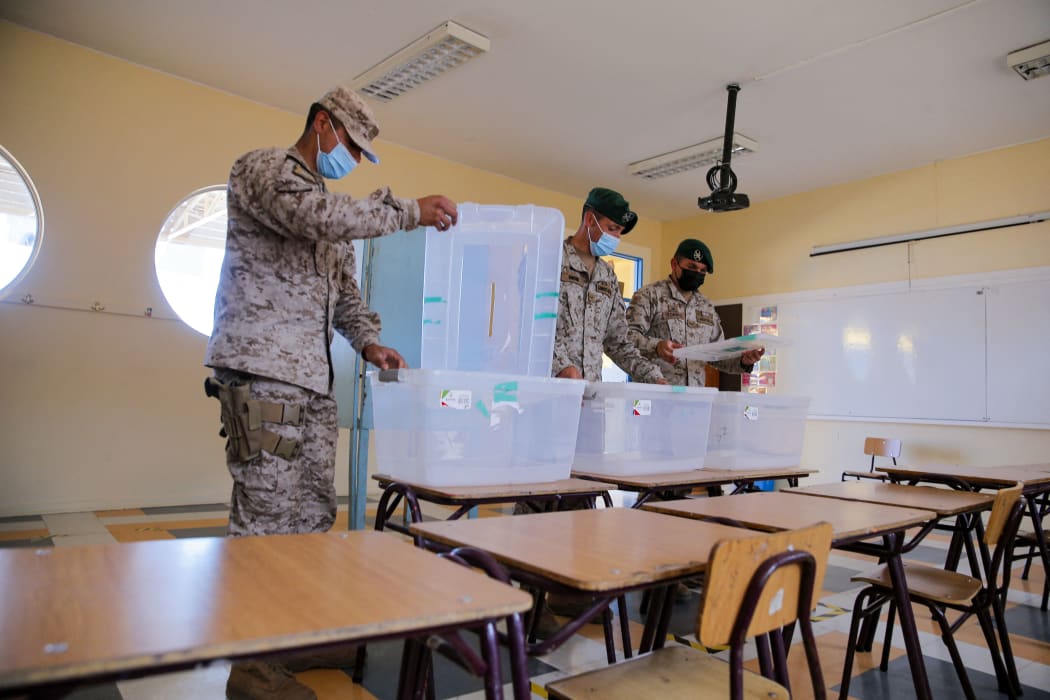Soldiers stand guard at a polling station in the Gualberto Kong Fernandez Basic School in Vallenar, Chile, on November 20, 2021, on the eve of Chile's general elections.
