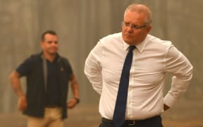 Australia's Prime Minister Scott Morrison (C) visits a resident's property in an area devastated by bushfires in Sarsfield, Victoria state on January 3, 2020.
