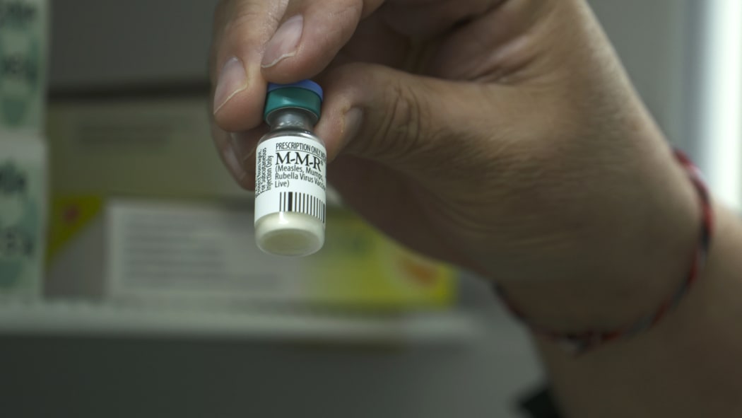 Dr Richard Hulme holding Measles Vaccine