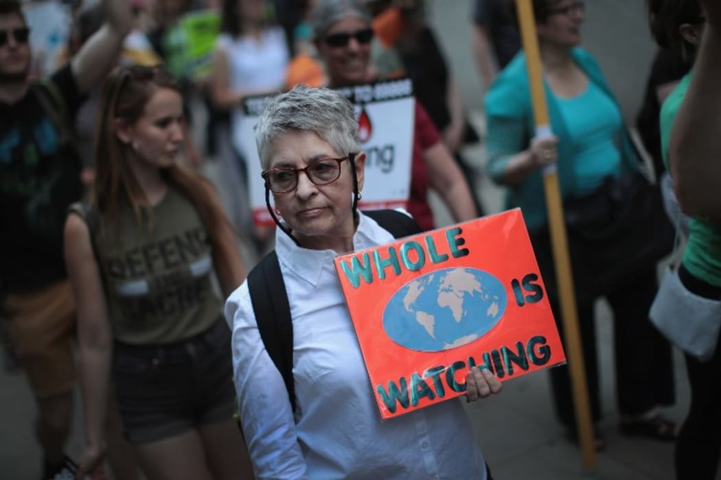 Demonstrators protest President Donald Trump's decision to exit the Paris climate change accord.