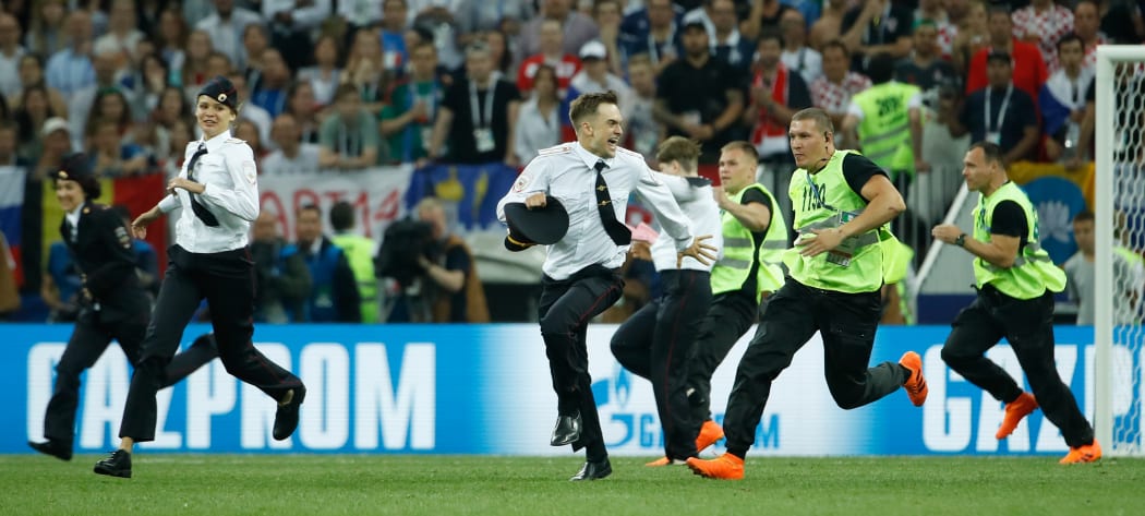 Stewards remove pitch invaders during the Russia 2018 World Cup final football match between France and Croatia at the Luzhniki Stadium in Moscow on July 15, 2018.
